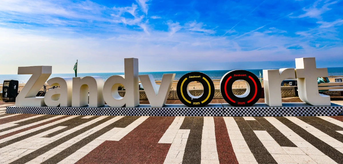Zicht op de kustlijn en het strand van Zandvoort met het iconische bord met de stadsnaam
