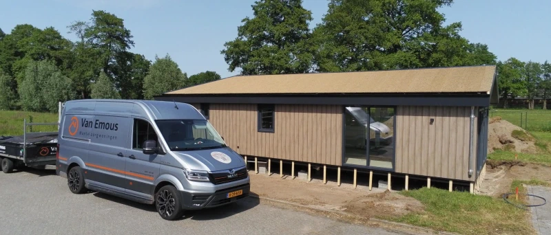 Bus van Van Emous bij een net geplaatste woning