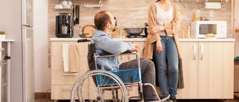 Vrouw helpt oudere moeder met het invullen van papierwerk aan tafel